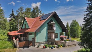 A two-story house with a sloped roof, a stone foundation, and a red-tiled roof. - Apartment V+K – Cozy 2BR near High Tatras, Štrba (Štrba)