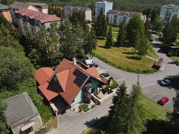 Un quartier résidentiel comprenant plusieurs immeubles d’appartements, une rue principale et des espaces verts environnants.