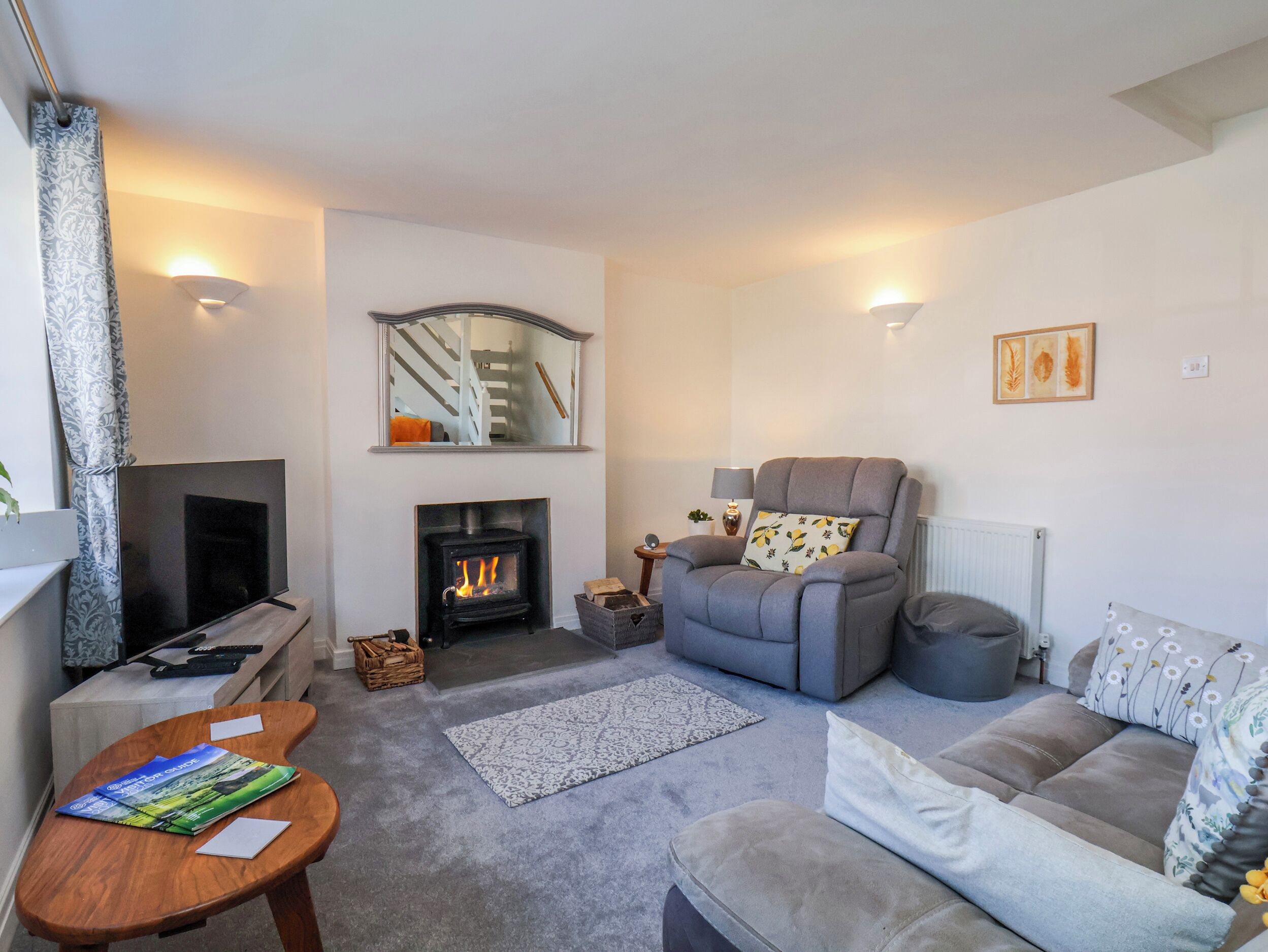 Un salon avec une cheminée, un canapé, un fauteuil inclinable, un téléviseur et une table basse.