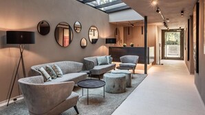 A modern interior with a sofa set, round mirrors, and a skylight. - Marchegg Apartments (Naturno)