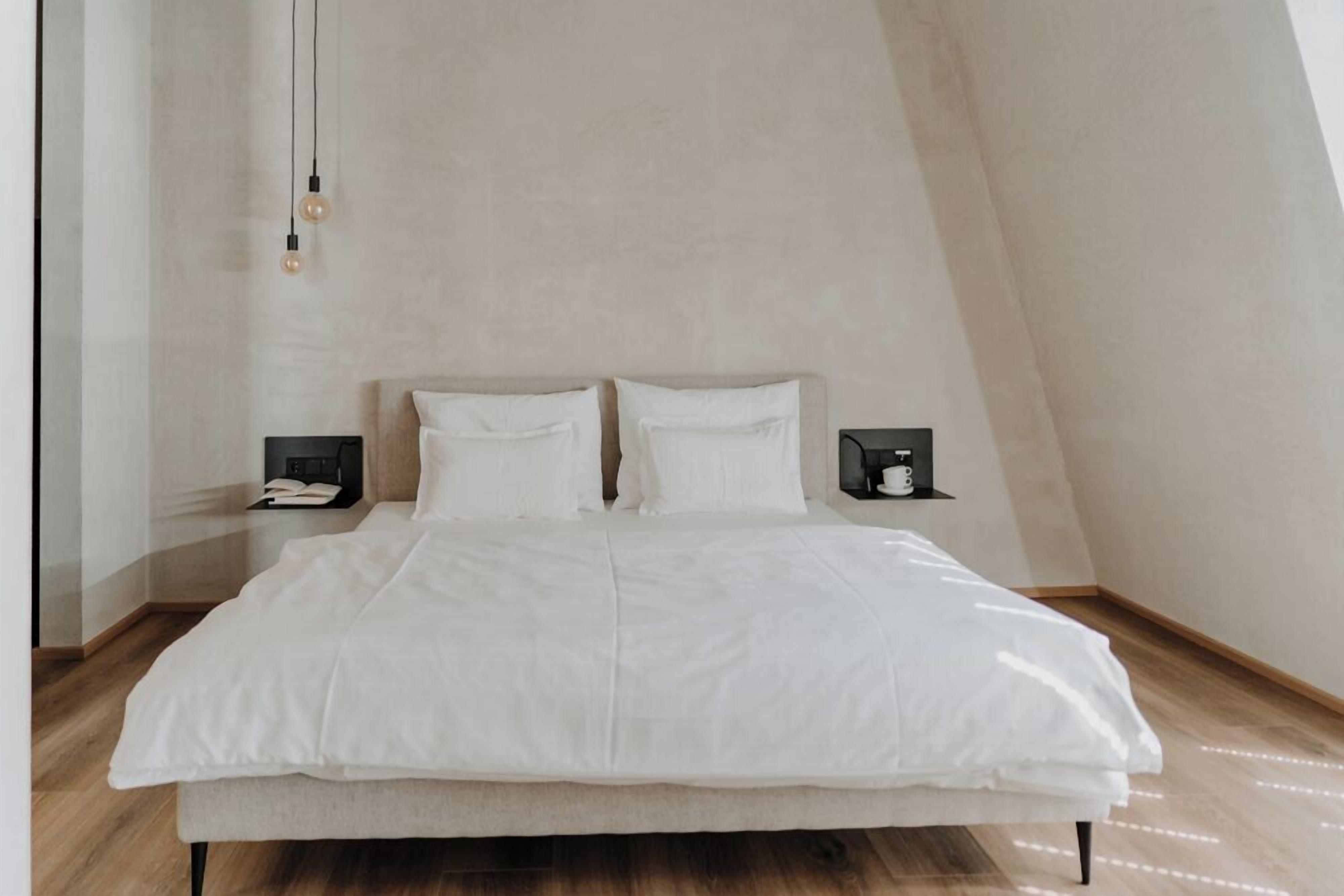 Ein Schlafzimmer mit einem Bett, zwei Nachttischen und einer Wandleuchte.
