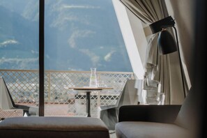 A balcony with a table, chairs, and a view of the sky. - Marchegg Apartments (Naturno)