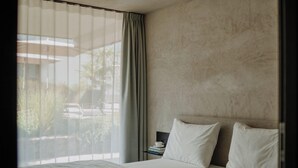 A hotel room with a bed, a nightstand, a cup, and a view of the outside. - Marchegg Apartments (Naturno)