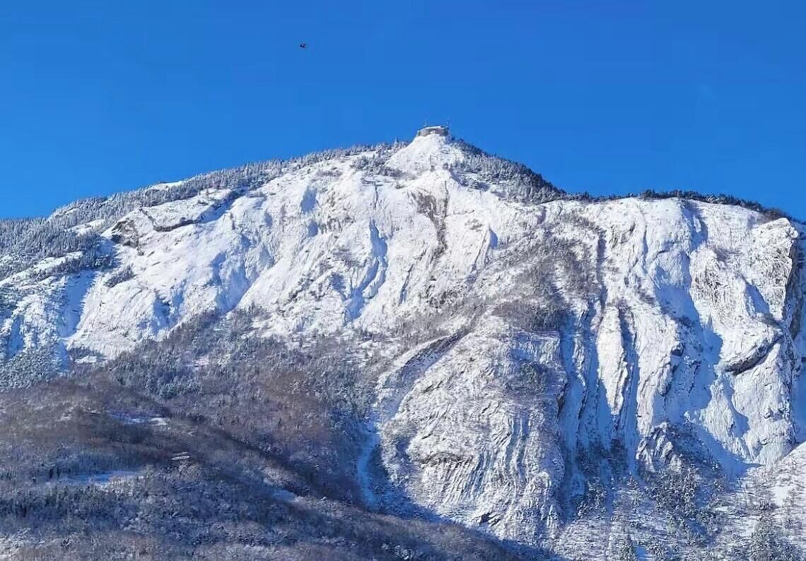 A snow-covered mountain with a clear sky.