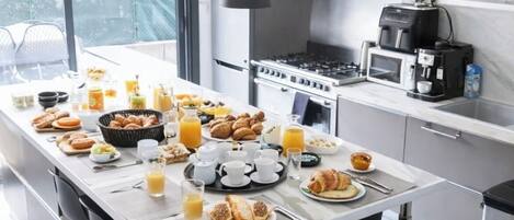 Una cocina moderna con comedor, electrodomésticos de acero inoxidable y espacio para el desayuno.