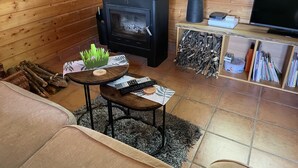 A cozy living room with a fireplace, a television, and a small table with decorative items.