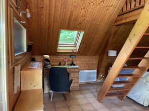 A wooden cabin with a desk, chair, and a window overlooking greenery. - Cottage-Wet room-Cottage-Mountain view (Aleu)
