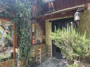 A rustic building with stone walls, wooden beams, and a metal door.