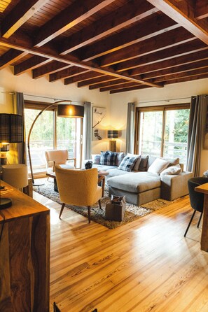 A cozy living room with wooden beams, a sofa, armchairs, and a coffee table. - Chalet in the mountains, ideal for families! (Bolquère)