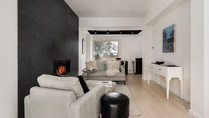 Ein modernes Wohnzimmer mit Kamin, einer Couch, einem Couchtisch und einem Schreibtisch.