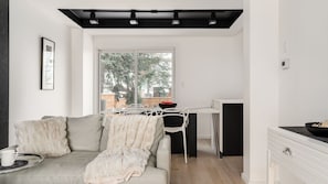 Una sala de estar moderna con un sofá, una mesa de comedor y una zona de cocina.