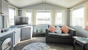 Een gezellige woonkamer met een televisie, bank en haard.