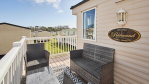 Een terras met rieten meubilair en een bordje met daarop Willerby The Richmond Holiday Homes Ltd.