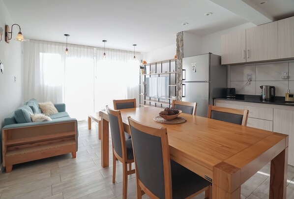 Una cocina moderna con una mesa de comedor, sillas y horno empotrado.