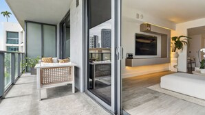 A modern living room with a sofa, a coffee table, and a TV mounted on the wall. - NEW! Luxury 1 BR Hyde Midtown Walk to Design District and Walk Evreywhere. (Miami)