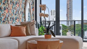 A modern living room with a sofa, pillows, a coffee table, and an orchid plant. - NEW! Luxury 1 BR Hyde Midtown Walk to Design District and Walk Evreywhere. (Miami)