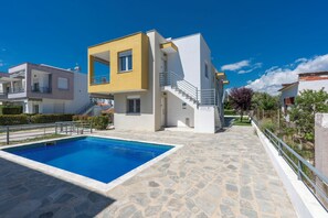 A modern two-story house with a swimming pool, stone patio, and a staircase leading to the upper floor. - SLV Danai 7 Apartments (Pangaio)