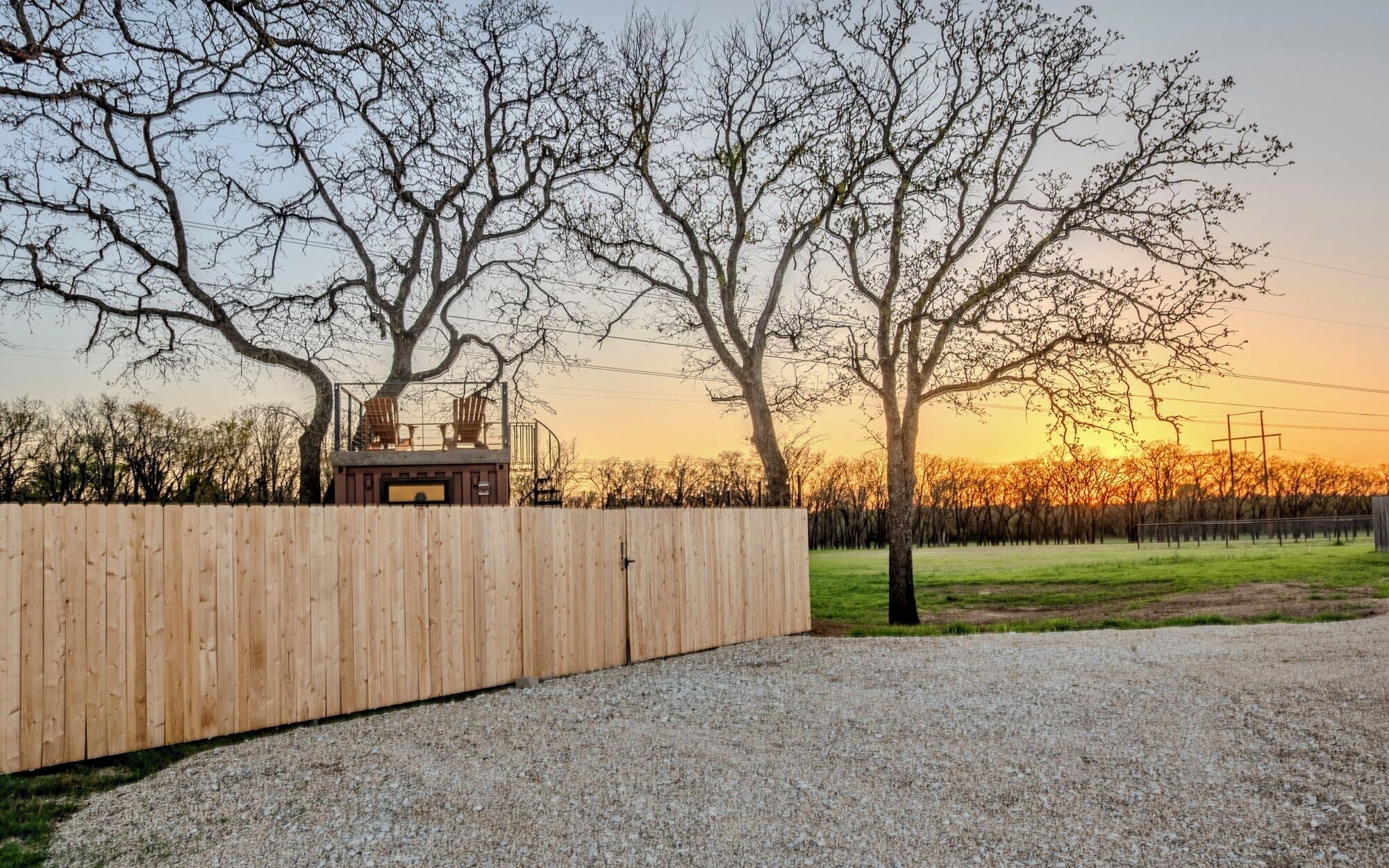 A wooden fence, a gravel path, and leafless trees.