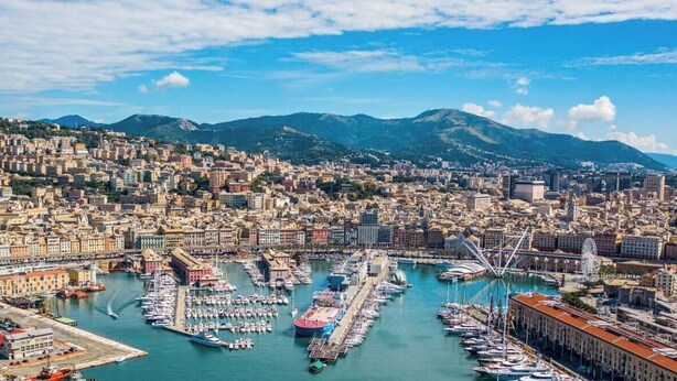 A coastal cityscape with a marina, buildings, and mountains in the background. - [New Modern Apt.] Center 10 min • Hyper WiFi • A/C (Genoa)