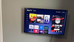 A flat-screen TV mounted on a wall displaying a streaming service interface with various content options. - Ruppside Retreat I Cozy 2BR I 15m to RRG I Wi-Fi (Stanton)