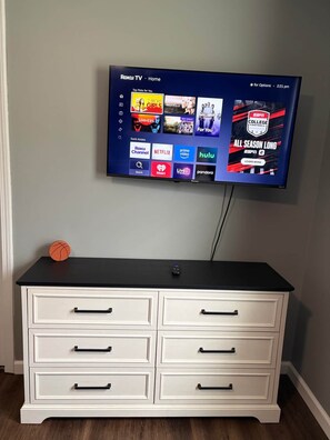 A flat-screen TV mounted on a wall displaying a streaming service interface with various content options. - Ruppside Retreat I Cozy 2BR I 15m to RRG I Wi-Fi (Stanton)