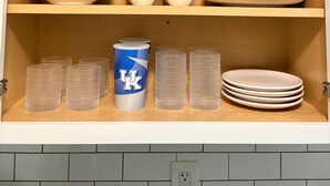 Un meuble avec des étagères contenant des bols, des tasses et des verres.