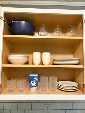 A cabinet with shelves containing bowls, cups, and glasses. - Ruppside Retreat I Cozy 2BR I 15m to RRG I Wi-Fi (Stanton)