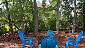 Three blue chairs arranged in a semi-circle facing a pile of logs and a building in the background. - Ruppside Retreat I Cozy 2BR I 15m to RRG I Wi-Fi (Stanton)