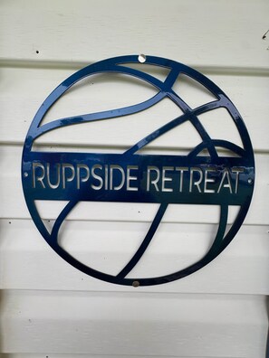 A circular sign with the text 'RUPPSIDE RETREAT' mounted on a white wall. - Ruppside Retreat I Cozy 2BR I 15m to RRG I Wi-Fi (Stanton)