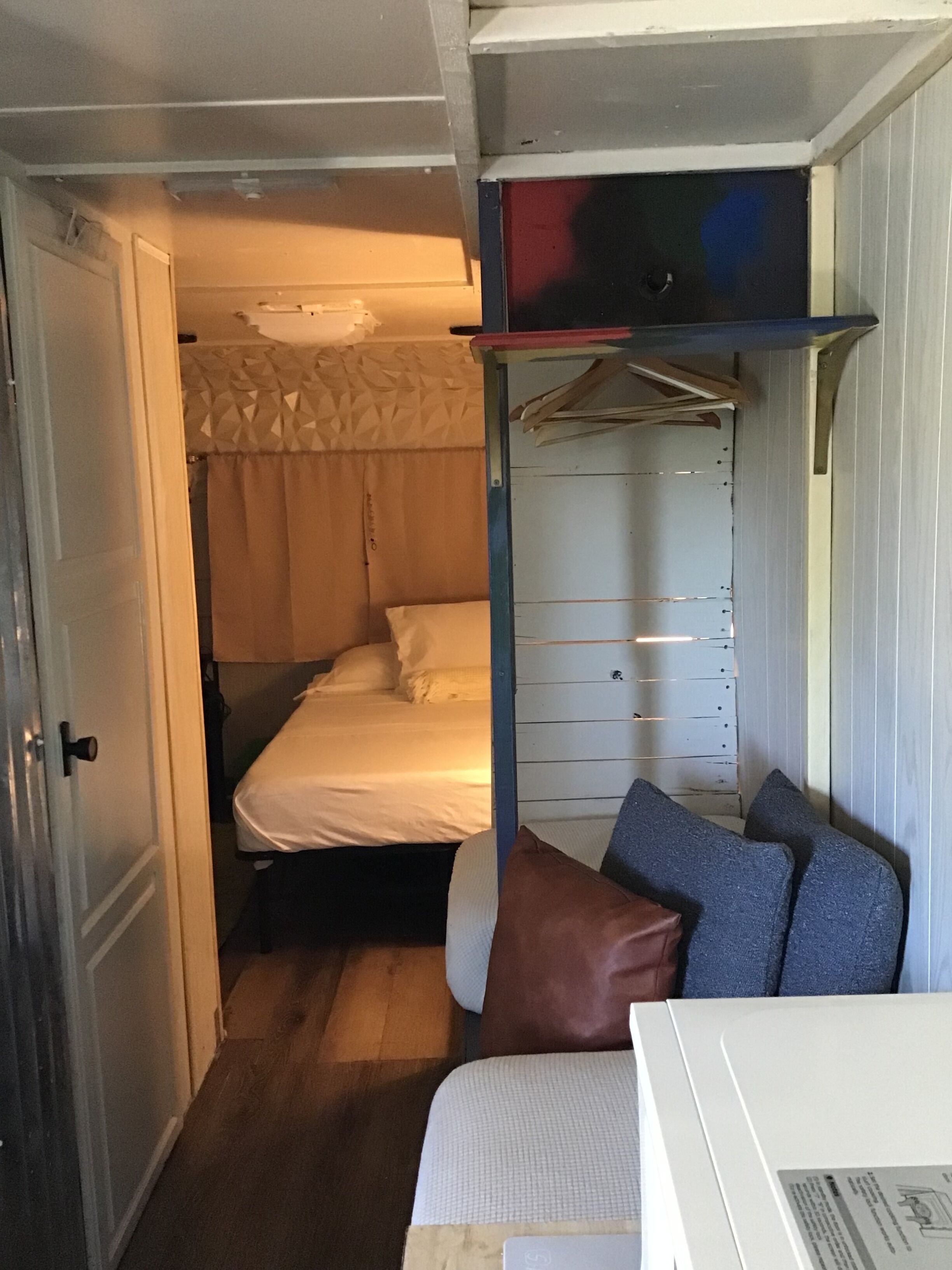 A compact room with a bunk bed, a small desk, and a wardrobe.