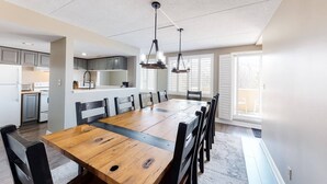 Una cocina amplia con electrodomésticos modernos, un comedor con una gran mesa de madera y un interior luminoso con luz natural.