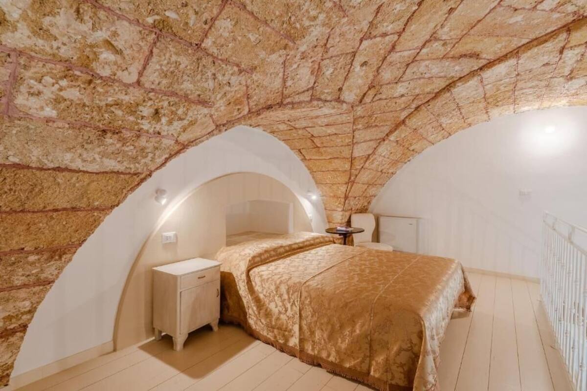Ein Schlafzimmer mit einer Tonnen Decke, einem Bett, einem Nachttisch und einem kleinen Tisch mit einem Stuhl.