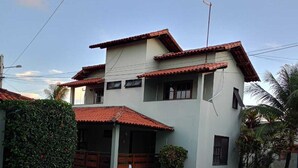Ein zweistöckiges Haus mit Swimmingpool, Steinterrasse und einem roten Ziegeldach.