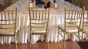 A conference room with a long table, chairs, a projector screen, and a ceiling fan. - The Q Hotel Restaurant (Tagaytay)