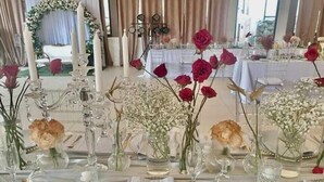 A table set for a formal event with clear glassware, white napkins, and floral centerpieces. - The Q Hotel Restaurant (Tagaytay)
