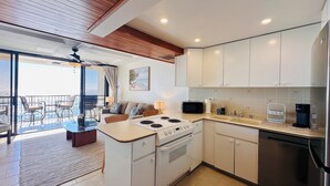 A modern kitchen with a stove, microwave, and stainless steel refrigerator. - Ocean-Front Condo•Semi-Private Beach•Pool•Hot Tub•Tennis.Free Parking. (Waianae)