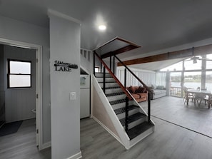 Ein modernes Interieur mit Treppe, Wohnbereich und Seeblick.