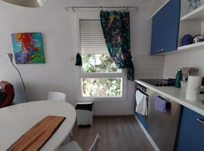 A kitchen with a window, a sink, a stove, and a countertop. - Le soleilado – 150m from the beach and city center (Cavalaire-sur-Mer)
