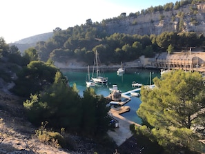 A coastal marina with boats docked, surrounded by cliffs and dense greenery. - Le soleilado – 150m from the beach and city center (Cavalaire-sur-Mer)