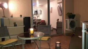 A room with a glass table, chairs, a small table with a candle, and a doorway leading to another room. - Apartment with terrace and parking in Ajaccio (Ajaccio)