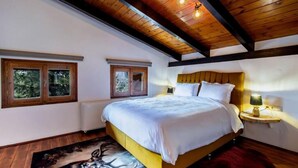 A bedroom with a wooden ceiling, a bed with white bedding, two windows, and a nightstand with a lamp. - MZ Reindeer (Distomo-Arachova-Antikyra)