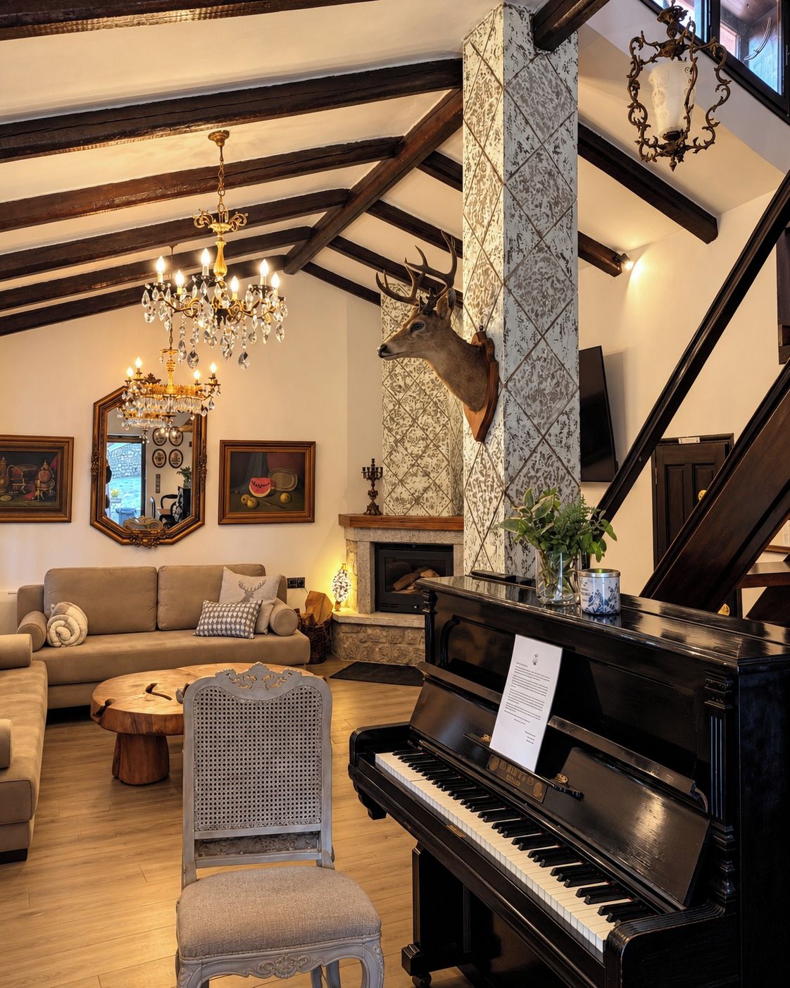 Una sala de estar con un piano de cola, una chimenea, una escalera y una cabeza de ciervo montada en la pared.