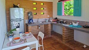 A compact kitchen with a refrigerator, sink, and dining area.