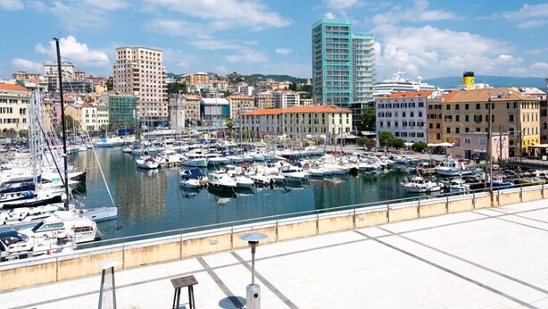 A marina with numerous boats docked, surrounded by buildings and a clear sky. - [Savona Old Town] Cruises 10 mins • Free WIFI (Savona)