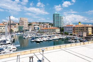 A marina with numerous boats docked, surrounded by buildings and a clear sky. - [Savona Old Town] Cruises 10 mins • Free WIFI (Savona)