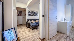 A modern interior with a sofa, a framed artwork, and a cabinet. - [Savona Old Town] Cruises 10 mins • Free WIFI (Savona)