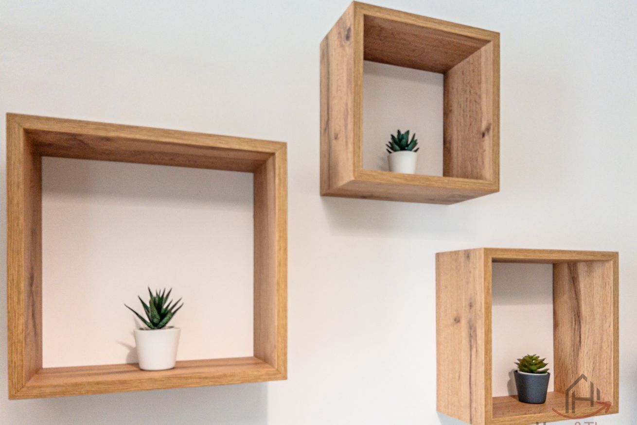 Three wooden wall-mounted shelves with potted plants.