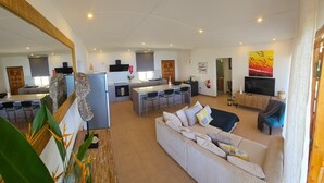 A spacious living area with a sofa, a dining table, and a kitchen area with a bar.
