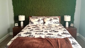 A bedroom with a bed, two bedside tables, and a green wall. - Nature's Nook I Cozy 2BR I 15m to RRG I Wi-Fi (Stanton)