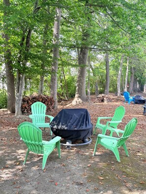 A campsite with green chairs around a covered grill, surrounded by trees. - Nature's Nook I Cozy 2BR I 15m to RRG I Wi-Fi (Stanton)